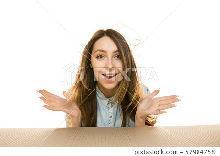 Young woman opening the biggest postal package isolated on white Young woman opening the biggest postal package isolated on white 57984758