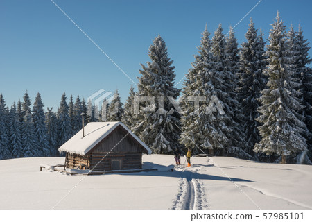 People near snow covered wood hut. Frosted forest People near snow covered wood hut. Frosted forest 57985101