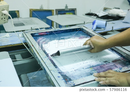 Hand pressing silk-screen printing, close up view. 57986116