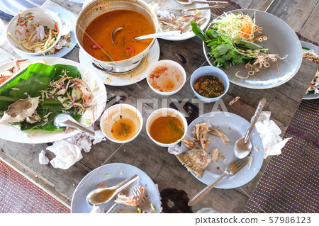 Leftover food on the wooden table. 57986123