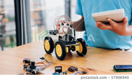 Boy with tablet pc computer programming electric 57986940