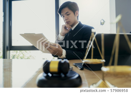 Male lawyer in the office with brass scale.. Male lawyer in the office with brass scale.. 57986958