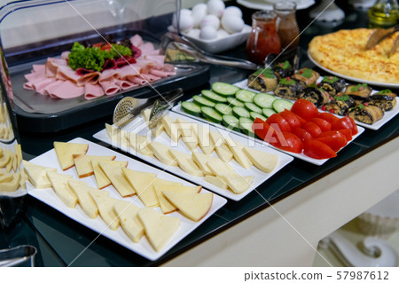 Rows of fresh cheese of different varieties, sauces and vegetables. Cheese as the main snack at 57987612