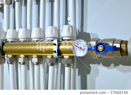 Close up of manometer, pipe, flow meter, water pumps and valves of heating system  57988336