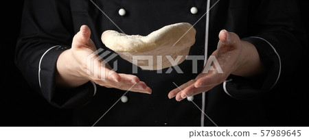 A female cook throws a yeast dough. A female cook throws a yeast dough. 57989645