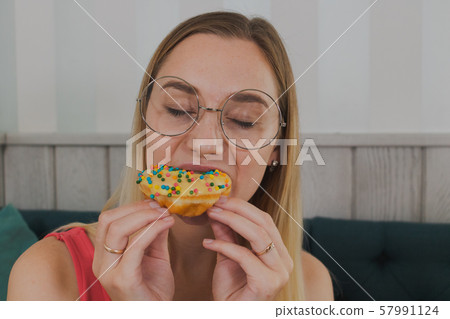 Girl in a cafe eats sweet and fresh desserts. Girl in a cafe eats sweet and fresh desserts. 57991124