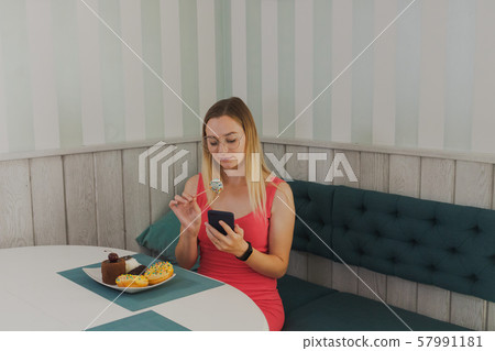 Beautiful girl sitting in a cafe with a phone in 57991181