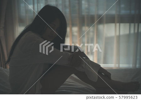 woman feel sad epressed and sitting in her bed 57995623