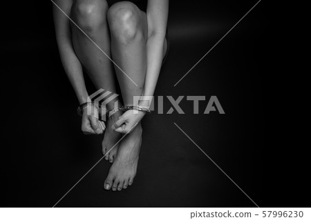 concept human trafficking, girl's hand in shackle on isolate black background concept human trafficking, girl's hand in shackle on isolate black background 57996230