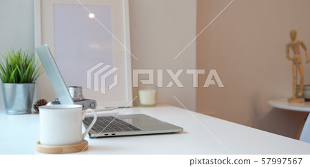 Minimal workplace with laptop computer and a cup 57997567
