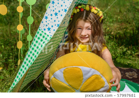 Young girl with pillows oranges in tent in park 57997681