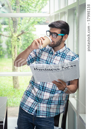 Young casual businessman reading business news in 57998138