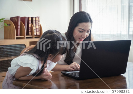 Beautiful asian mother and daughter working Beautiful asian mother and daughter working 57998281