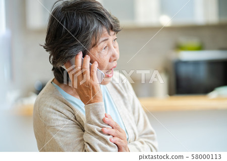 Senior woman talking on an uneasy senior smartphone, silver generation elderly woman portrait Senior woman talking on an uneasy senior smartphone, silver generation elderly woman portrait 58000113
