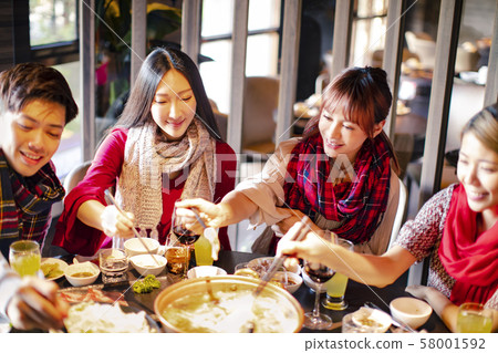 Happy friends having fun in hot pot restaurant Happy friends having fun in hot pot restaurant 58001592