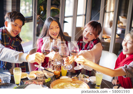 Happy friends having fun in hot pot restaurant Happy friends having fun in hot pot restaurant 58001593