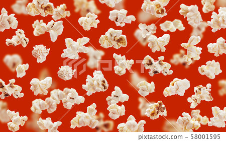Delicious pop corn grains closeup on red background Delicious pop corn grains closeup on red background 58001595