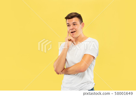 Caucasian young man's half-length portrait on yellow background Caucasian young man's half-length portrait on yellow background 58001649
