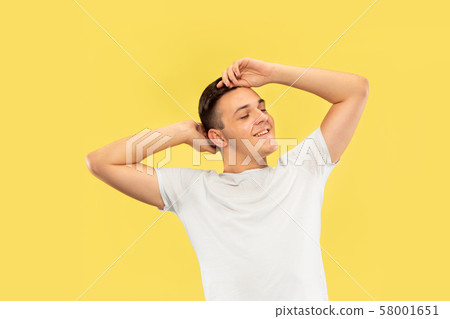 Caucasian young man's half-length portrait on yellow background Caucasian young man's half-length portrait on yellow background 58001651