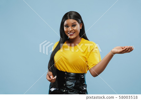 African-american young woman's half-length portrait on blue background African-american young woman's half-length portrait on blue background 58003518