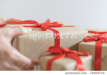 Hand of woman hold Christmas gift box on white background 58004530