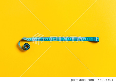 Diet concept, tape measure on yellow background. Diet concept, tape measure on yellow background. 58005304