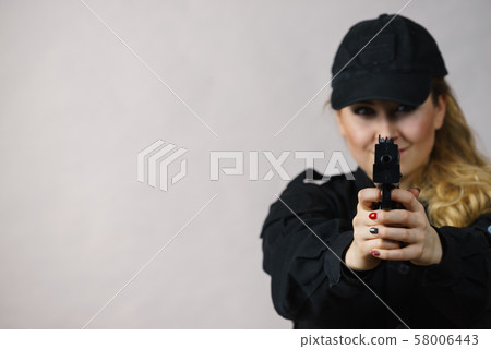 Woman holds gun in hands. 58006443