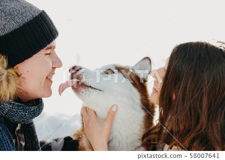 The happy couple with dog haski at forest nature The happy couple with dog haski at forest nature 58007641