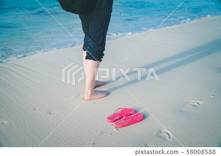 Bare feet and sandals on the sandy beach (the most beautiful Yonaha Maehama Beach in the Orient) 58008588