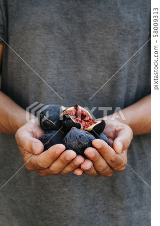 man with some figs in his hands man with some figs in his hands 58009313