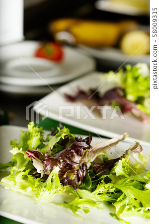 salad in preparation in a professional kitchen 58009315