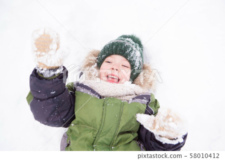 Little boy play with snow in the park. Christmas mood Little boy play with snow in the park. Christmas mood 58010412