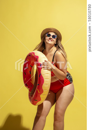 Young caucasian plus size female model's preparing for beach resort 58010780