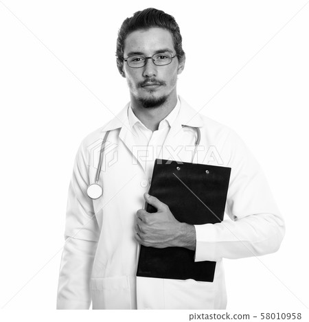 Studio shot of young handsome man doctor holding clipboard isolated against white background Studio shot of young handsome man doctor holding clipboard isolated against white background 58010958