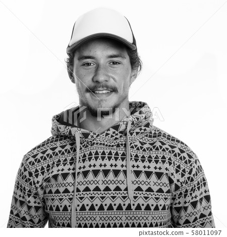 Studio shot of young happy man smiling while wearing cap isolated against white background 58011097