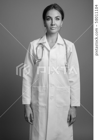 Young beautiful woman doctor against gray background 58011184