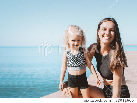 Young fit woman mom with little cute girl 58011669
