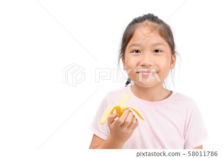 Little asian cute girl eats banana isolated on Little asian cute girl eats banana isolated on 58011786