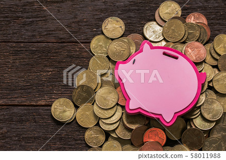 Pink piggy bank with coins on wooden background Pink piggy bank with coins on wooden background 58011988