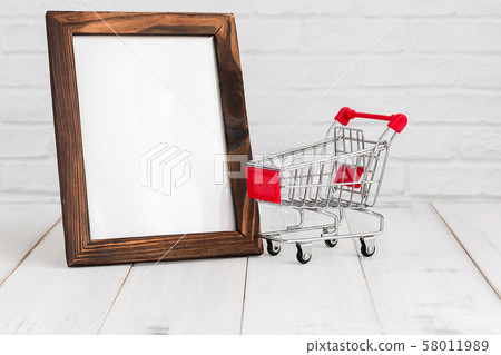 Photo frame and trolley shopping cart on white Photo frame and trolley shopping cart on white 58011989