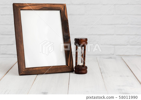 Photo frame and hourglass on white wood table with Photo frame and hourglass on white wood table with 58011990