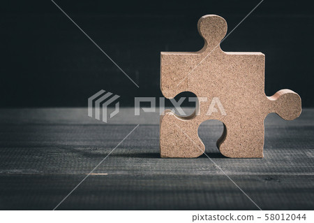 Wooden jigsaw puzzle on wood table background. 58012044