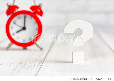 Question mark with alram clock on white wood table 58012055