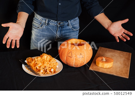 man makes an orange pumpkin for Halloween man makes an orange pumpkin for Halloween 58012549