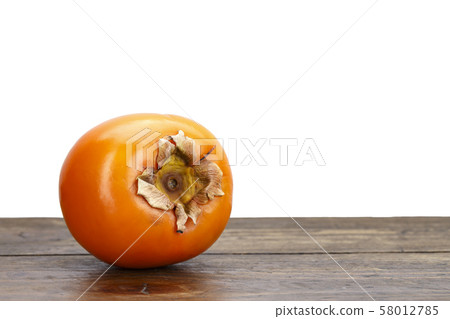 whole persimmons on the table 58012785