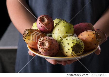 Female hands hold a plate with ripe fresh fruits 58013462