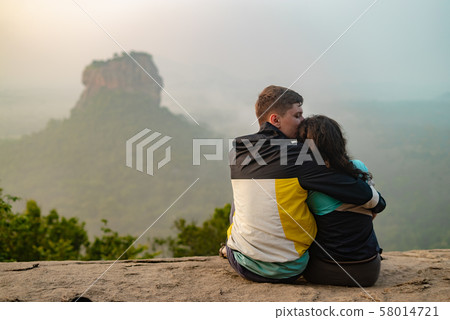A couple in love on a rock admires the beautiful views. A couple in love travels. Couple in Sri 58014721