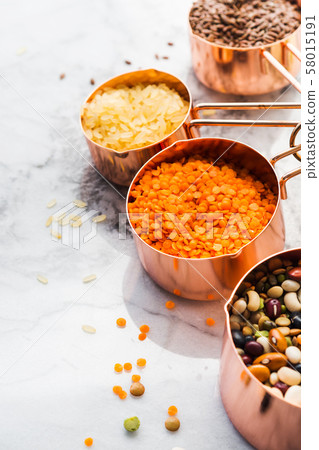 Copper cups with beans and cereal on marble 58015191