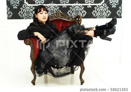 一個女人坐在哥特式洛麗塔角色扮演的椅子上 58021383