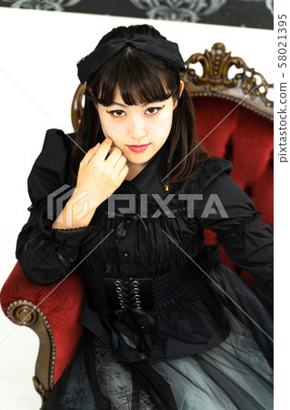 一個女人坐在哥特式洛麗塔角色扮演的椅子上 一個女人坐在哥特式洛麗塔角色扮演的椅子上 58021395